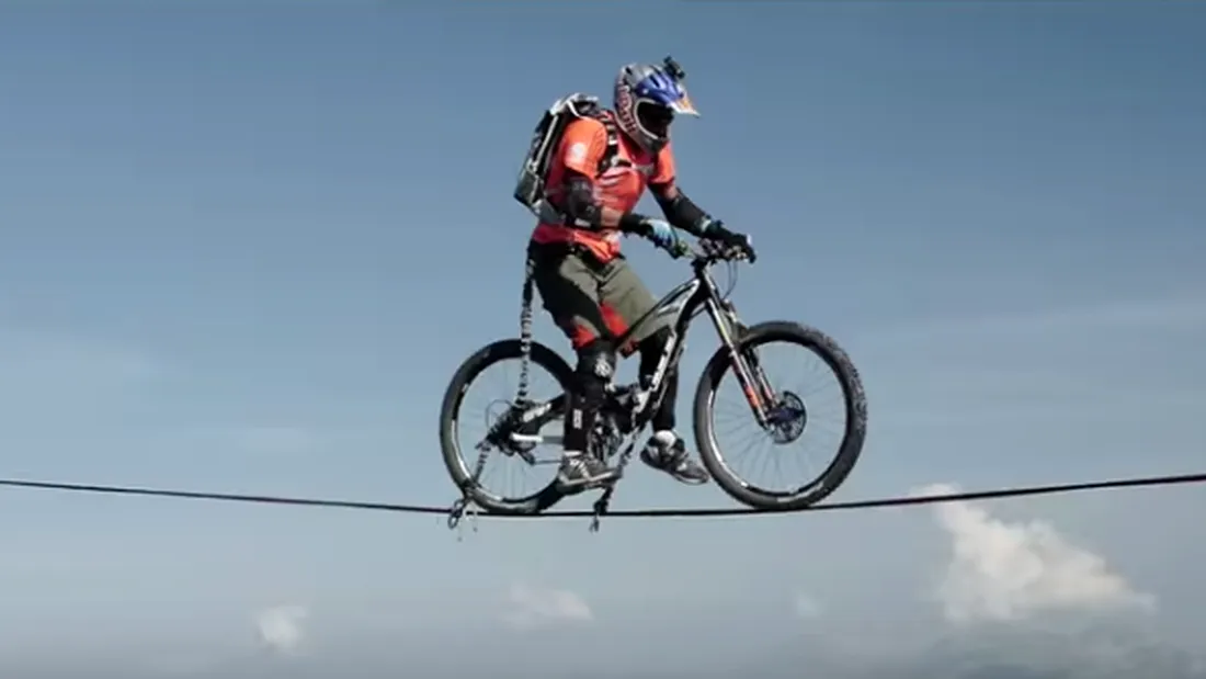 Fenomenal! Tipul asta reuseste sa treaca cu bicicleta la altitudinea asta pe o sfoara ingusta! Este extrem de periculos si dificil